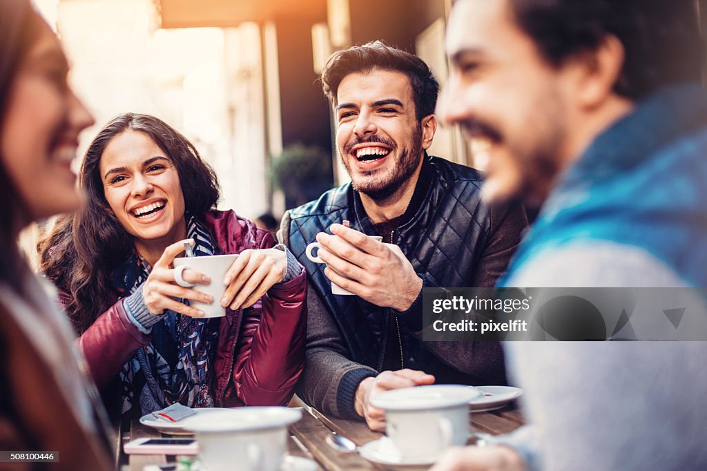 Smiling friends drinking coffee