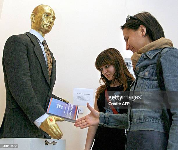 Visitors shake hand with a gold covered sculpture of the Russian President Vladimir Putin and receive an answer "I love You" in "Anna Akhmatova"...