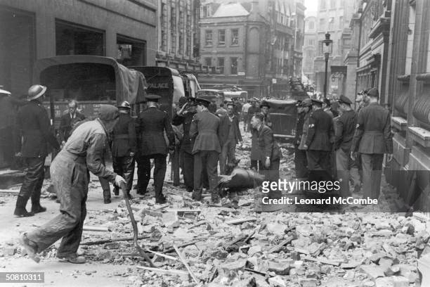 Rescue workers arrive at the scene of a V1 flying bomb explosion in the City of London, 15th July 1944. The remains of the bomb can be seen amongst...