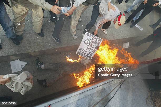 South Koreans help a protester who set himself on fire during a rally on May 7, 2004 in Seoul. Taxi driver Cho Kyung-Shik attempted suicide on Friday...