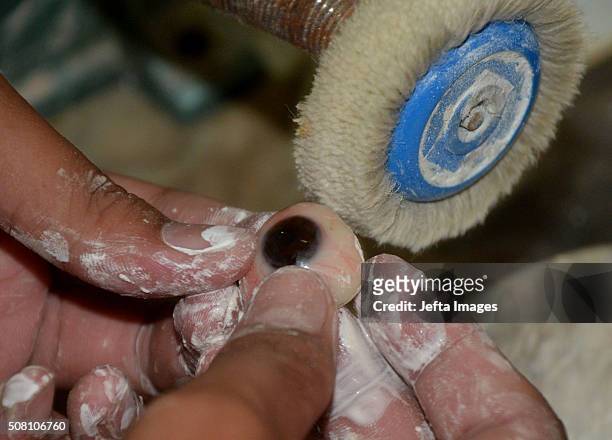 Worker shows prosthetic eyes for patients who have lost an eye, or suffered eye damage at a workshop on February 2, 2016 in Jakarta, Indonesia....