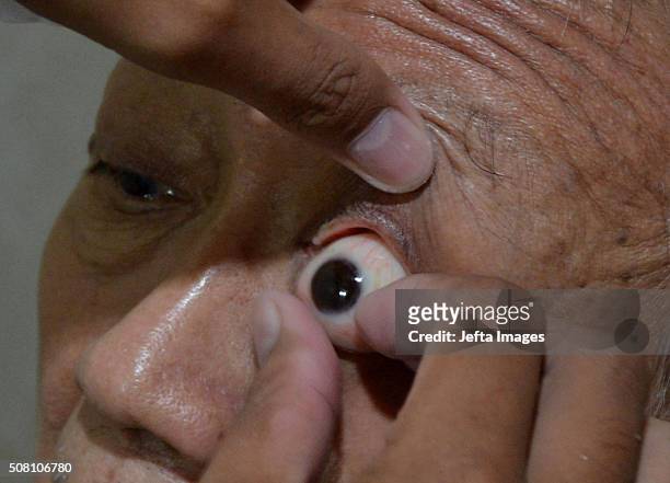 Worker puts prosthetic eyes for patients who have lost an eye, or suffered eye damage at a workshop on February 2, 2016 in Jakarta, Indonesia....