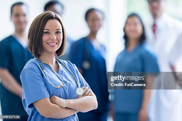 enfermeira feliz, de pé em um hospital - medical scrubs - fotografias e filmes do acervo