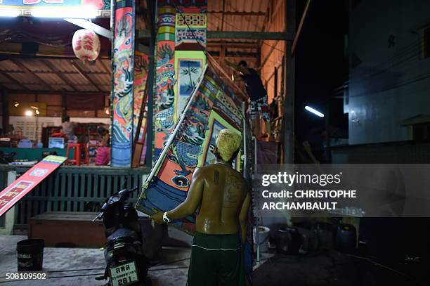 This picture taken on January 19, 2016 shows a man dismantling the stage at the end of a performance by Chinese opera artists in a village in Nakhon...