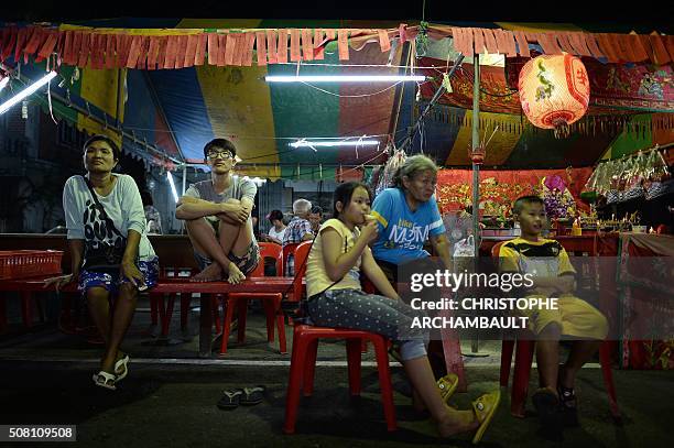 This picture taken on January 19, 2016 shows locals watching a stage performance by Chinese opera artists in a village in Nakhon Pathom province,...