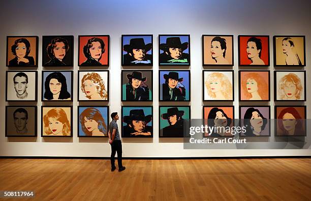 Member of staff poses next to a series of artworks by Andy Warhol at the Ashmolean Museum on February 2, 2016 in Oxford, England. The work forms part...