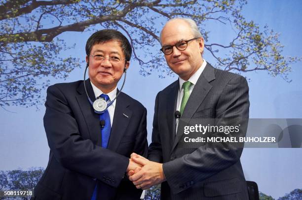 Chairman of Swiss farm chemicals giant Syngenta, Michel Demare shakes hand with Chairman of ChemChina Ren Jianxin during a press conference to...