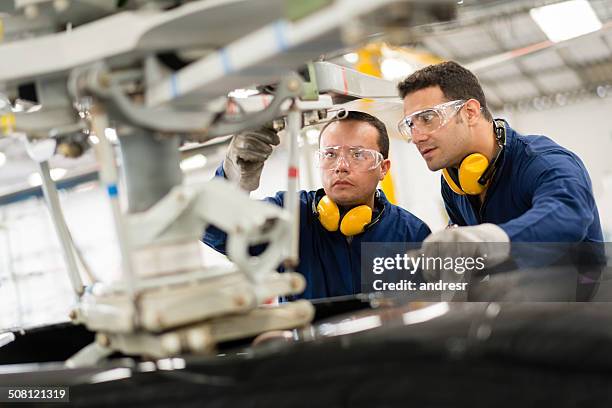 mechanics fixing a helicopter - aviation engineering imagens e fotografias de stock