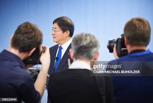 Photographers take pictures of Chinese Ren Jianxin, Chairman of ChemChina speaking during a press conference of the Syngenta's annual results...