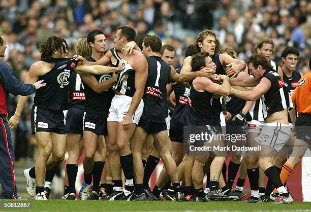 Players from both teams wrestle as they leave the ground at half time during the round seven AFL match between the Carlton Blues and the Collingwood...