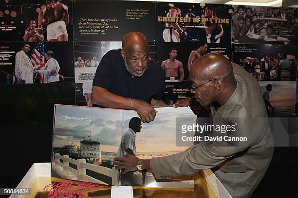 Laureus Academy Member Edwin Moses pose for a picture next to photographer Howard Bingham as they reveal Bingham's book GOAT May 8, 2004 at the...