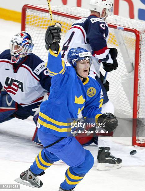 Per-Johan Axelsson of Sweden celebrates a scored goal against goalie Mike Dunham and defenseman Eric Weinreich of the USA during the Semifinals match...