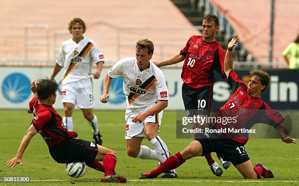 Midfielder Andreas Herzog of the Los Angeles Galaxy moves the ball past Eric Quill, Brad Davis and Simo Valakari of the Dallas Burn at the Cotton...