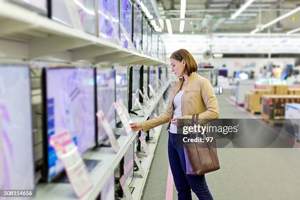 femme choisit un téléviseur dans le magasin - electrical equipment photos et images de collection