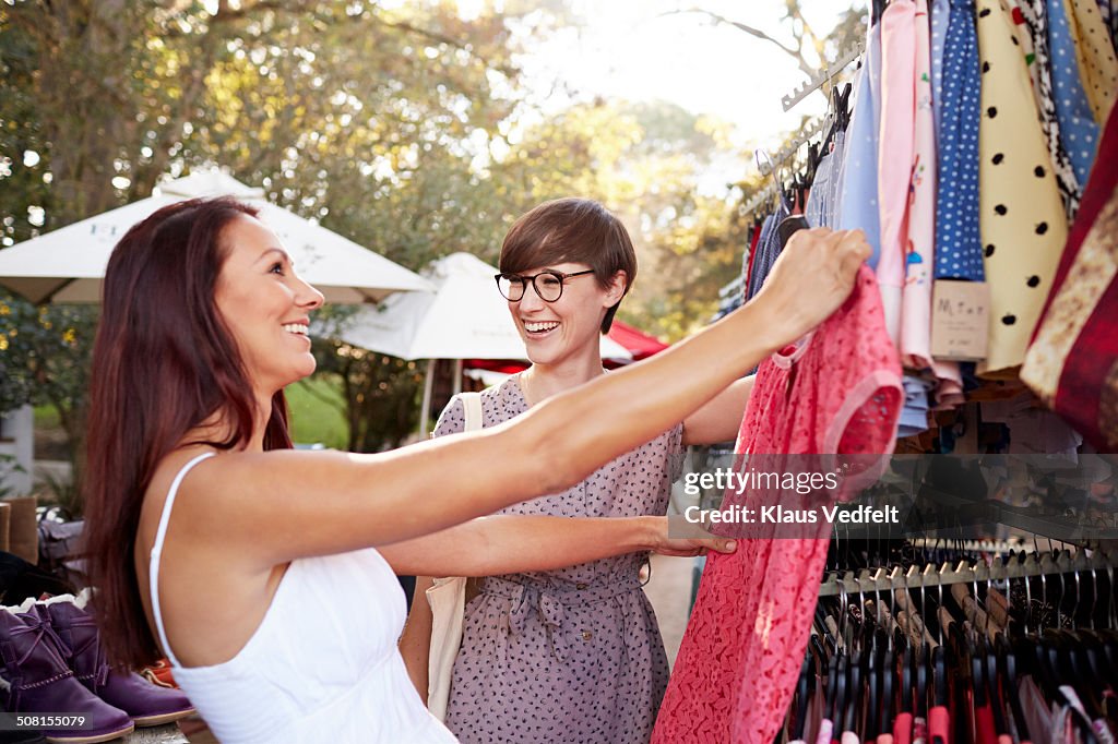 Girlfriends looking at clothes at market