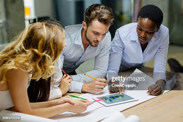 multiethnic team of architects reviewing architectural model in the office. - motion study stock pictures, royalty-free photos & images