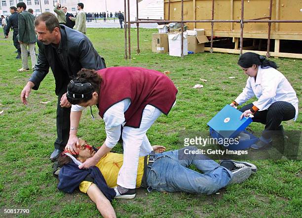 Paramedic tries to help Reuters news agency journalist Adlan Khasanov, who was fatally wounded in a blast during Victory Day celebrations May 9, 2004...