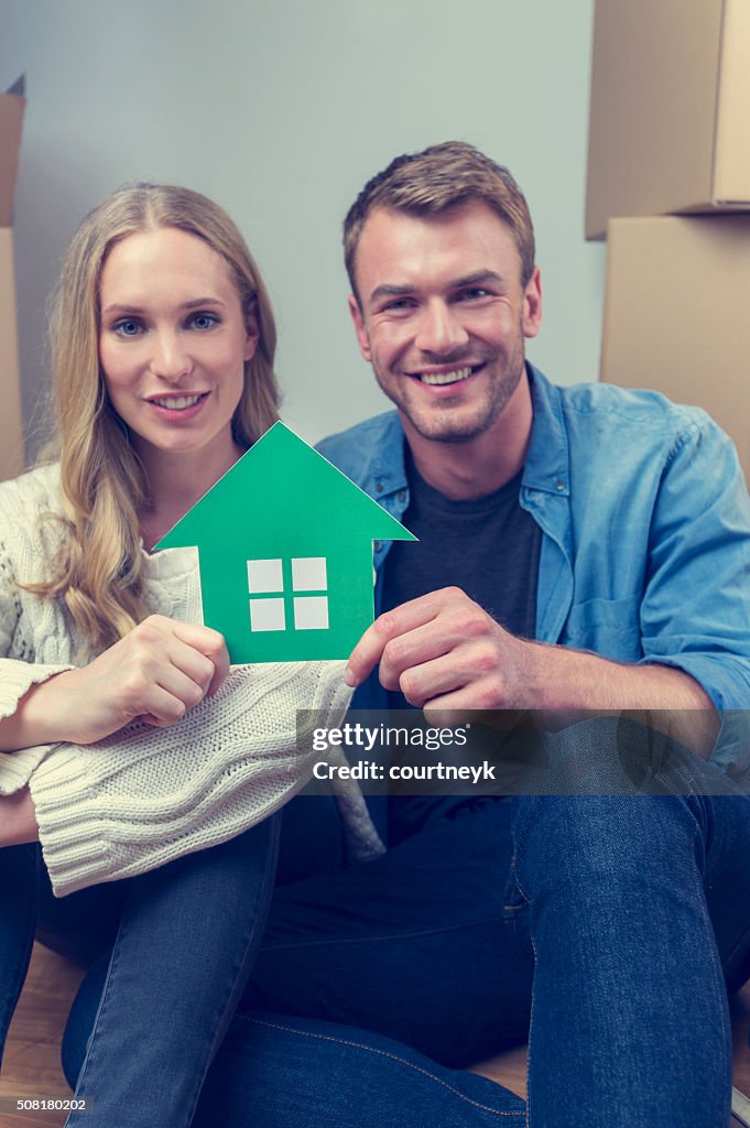 Paar mit Pappe Umzug Kartons und Haus-symbol