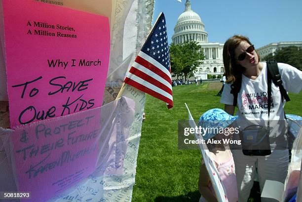 Cassandra Johnson, of Alexandria, Virginia, reads messages to her daughter Faye Javaudin as they browse the Million Stories Quilt during a rally...