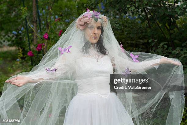 veiled bride with arms out, covered in butterflies. - fairytale wedding stock pictures, royalty-free photos & images