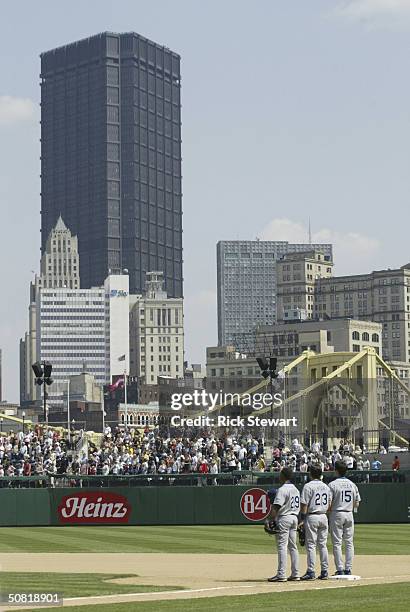 Adrian Beltre, Robin Ventura, and Shawn Green of the Los Angeles Dodgers pause during the singing of "God Bless America" during their game against...