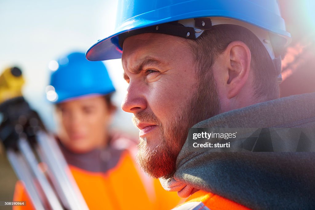Two construction site surveyors