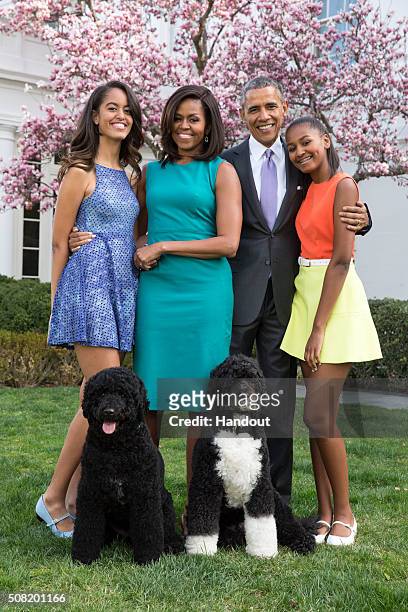 President Barack Obama, First Lady Michelle Obama, and daughters Malia and Sasha pose for a family portrait with their pets Bo and Sunny in the Rose...