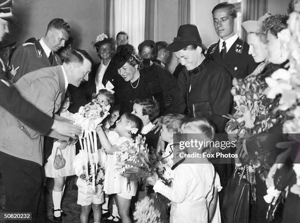 Nazi Flower German dictator Adolf Hitler receives posies of flowers from a group ...