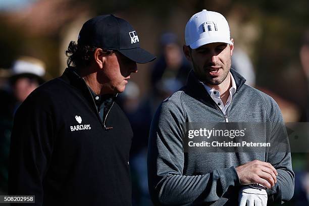 Quarterback Christian Ponder talks with Phil Mickelson on the first green during the pro-am for the the Waste Management Phoenix Open at TPC...