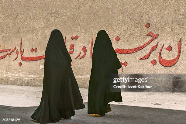 street scene women in black chador in shiraz, iran - niqab stockfoto's en -beelden