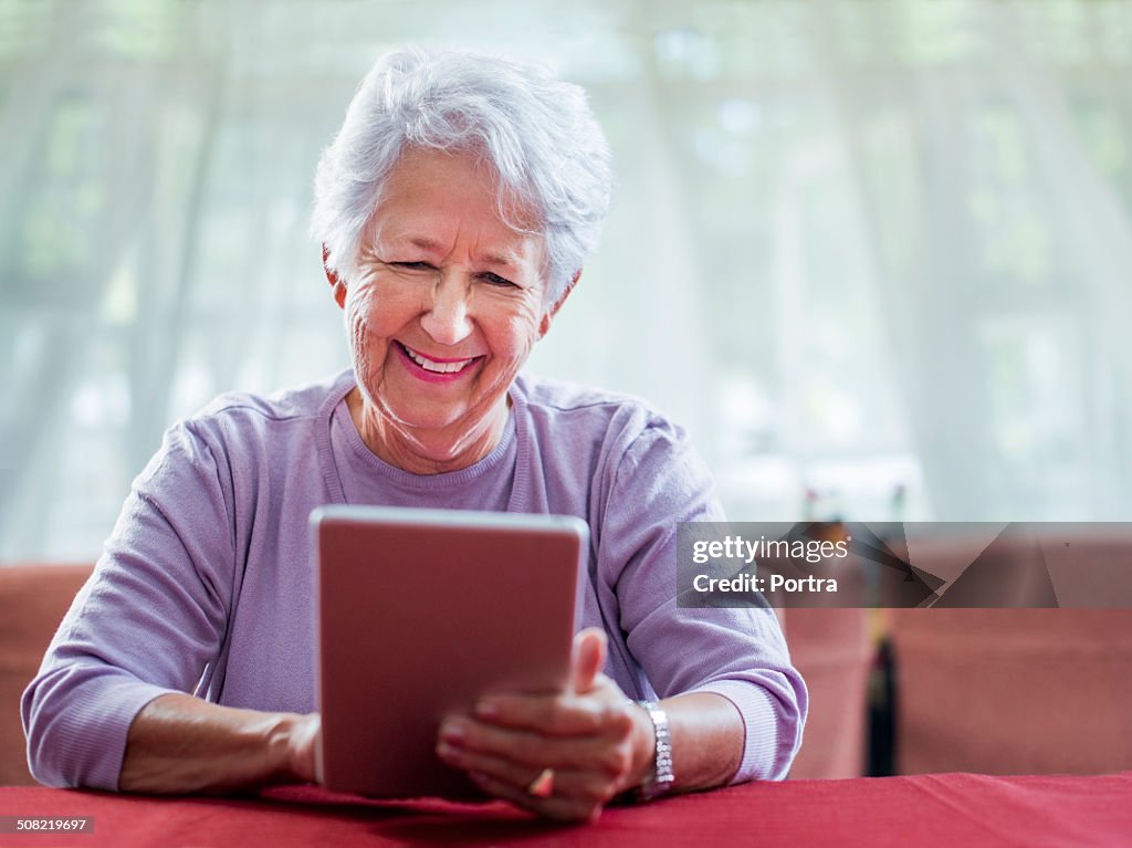 Happy senior woman using digital tablet