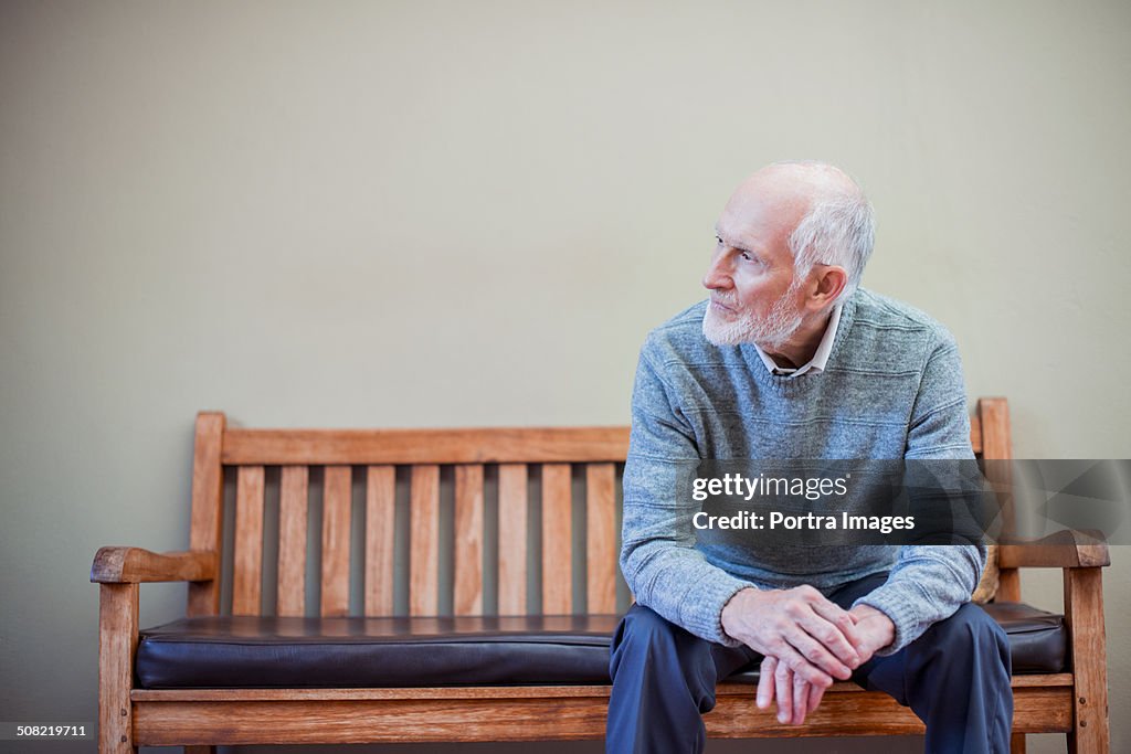 Thoughtful senior man on bench at nursing home