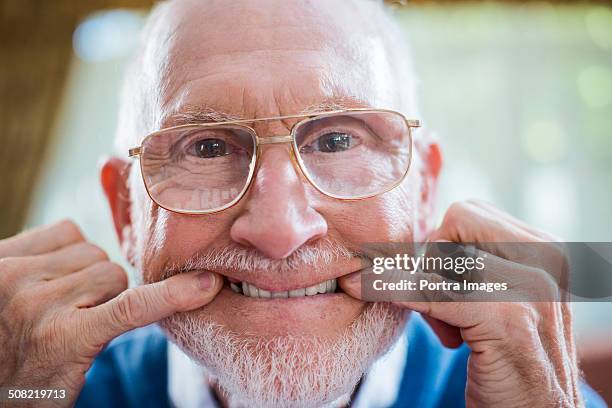 funny senior man with fingers in mouth - nursing home smiling ストックフォトと画像