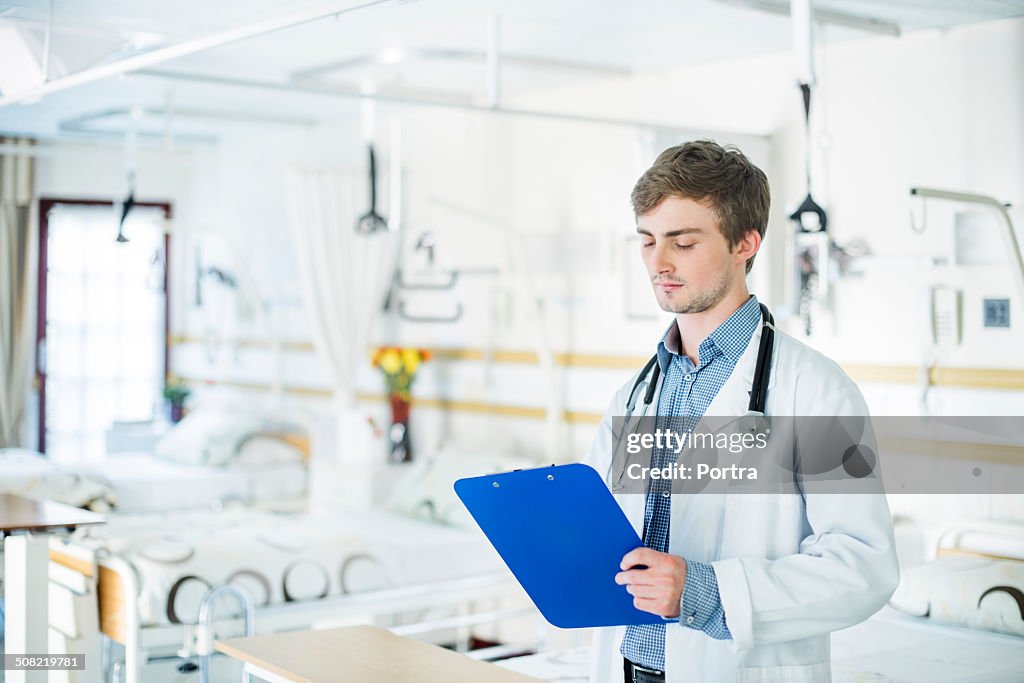 Doctor with clipboard in hospital ward