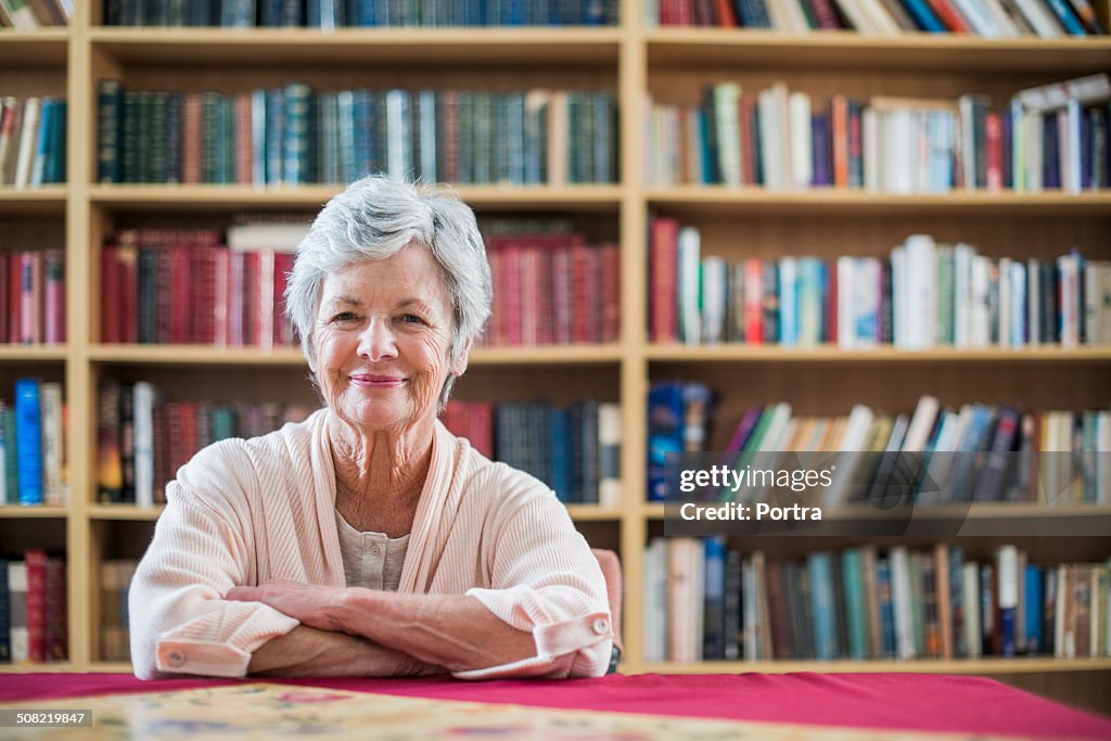 Happy senior woman sitting in library