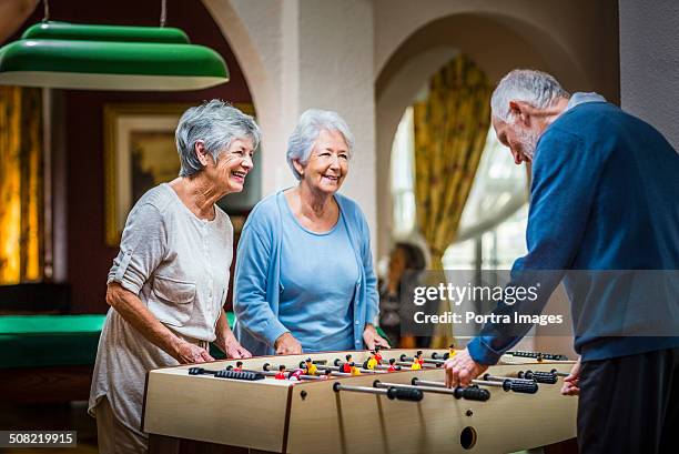 senior people playing foosball at nursing home - activity bildbanksfoton och bilder