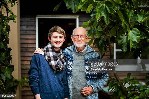 grandson with grandfather standing in yard - regular man stock pictures, royalty-free photos & images