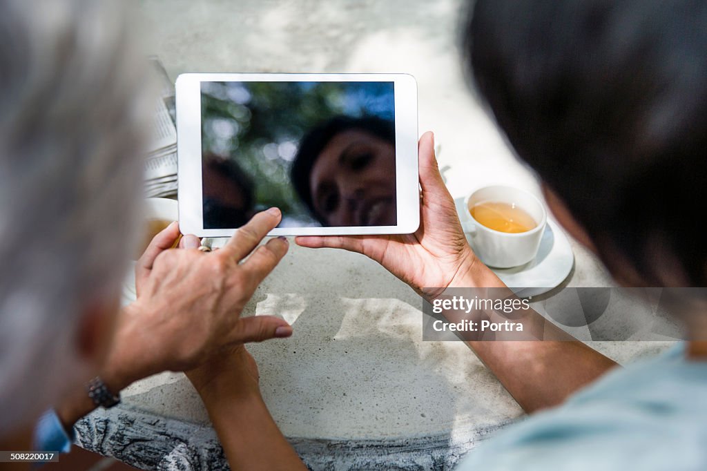 Caretaker using digital tablet with senior woman