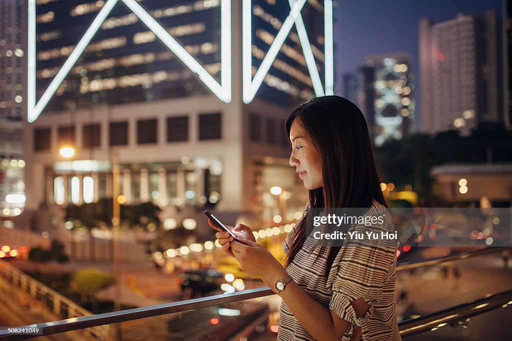 Female using smartphone with smile in city