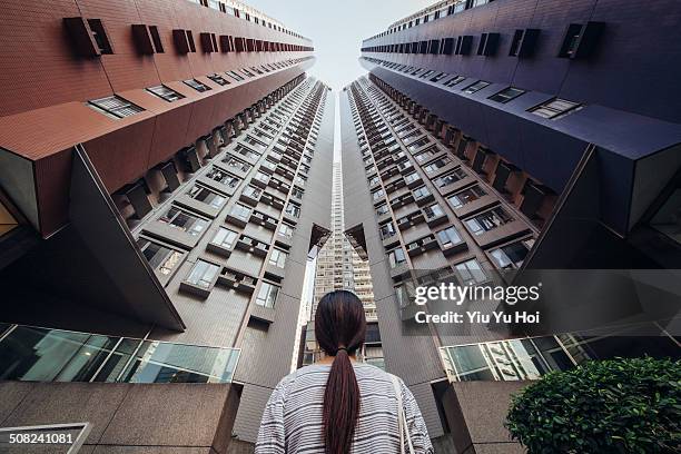 desperate asian female looking up at city jungle - building hong kong stock pictures, royalty-free photos & images