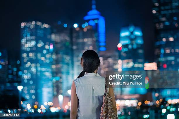 young female overlooking the stunning view of city - asien metropole nachtleben stock-fotos und bilder