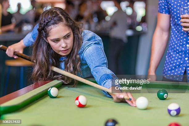 young australian aboriginal woman playing pool in a bar - aboriginal girl stock pictures, royalty-free photos & images