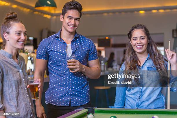 group of young people playing pool in a bar - australian pub stock pictures, royalty-free photos & images