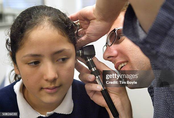 Dr. Michael Paul, with the Pediatric Mobile Health Unit of Loyola University Medical Center, performs a physical exam for incoming fifth-graders on...