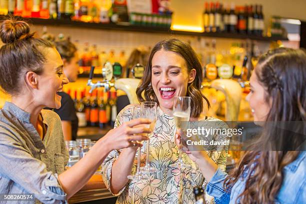 young women toasting with champagne in a bar - australian pub stock pictures, royalty-free photos & images