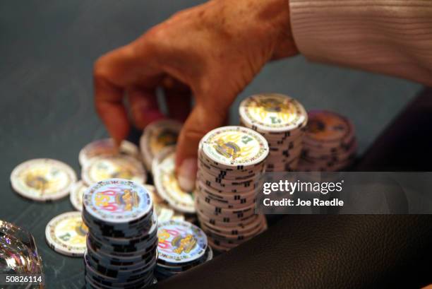 Poker player prepares to throw her chips on the table May 11, 2004 during the grand opening for the Seminole Hard Rock Hotel and Casino in Hollywood,...