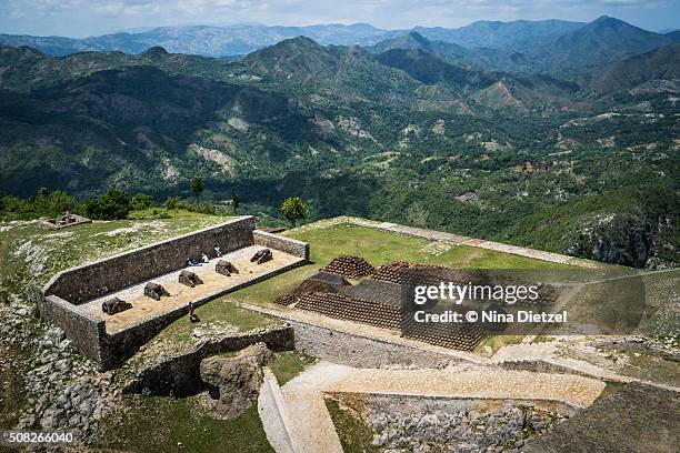 view from the citadelle laferrière, of its own field of cannons, massive stacks of cannon balls, and the surrounding mountains - citadel haiti stock pictures, royalty-free photos & images