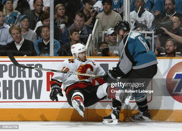 Jason Marshall of the San Jose Sharks puts a hit on Jarome Iginla of the Calgary Flames during game two of the 2004 NHL Western Conference Finals May...