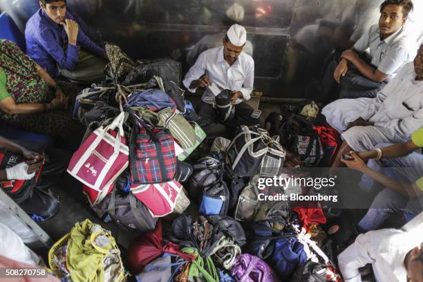 Dabbawala Dadabhau Shivaji arranges lunch bags as he rides a train in Mumbai, India, on Tuesday, Dec. 22, 2015. Food apps, after a boom in start-ups...