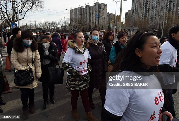 Investors in Chinese online peer-to-peer lender Ezubao chant slogans during a protest in Beijing on February 4, 2016. The protest came days after...